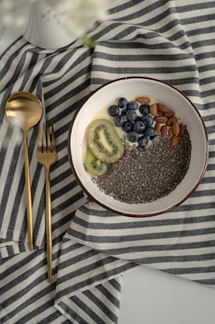 Fresh chia seeds scattered on a natural fiber cloth with sunlight highlighting their texture.