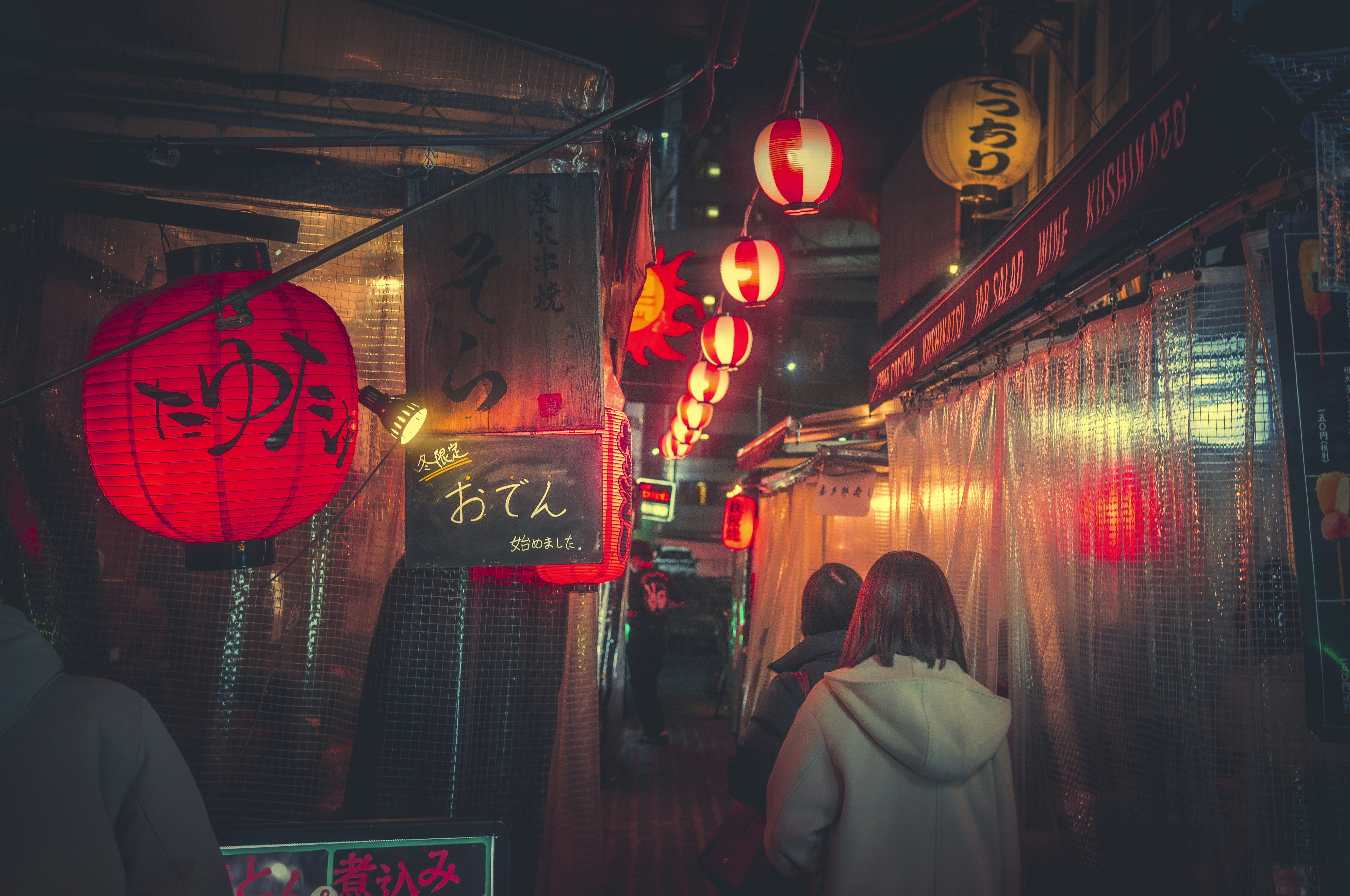 a woman walking down a dark alley way at night