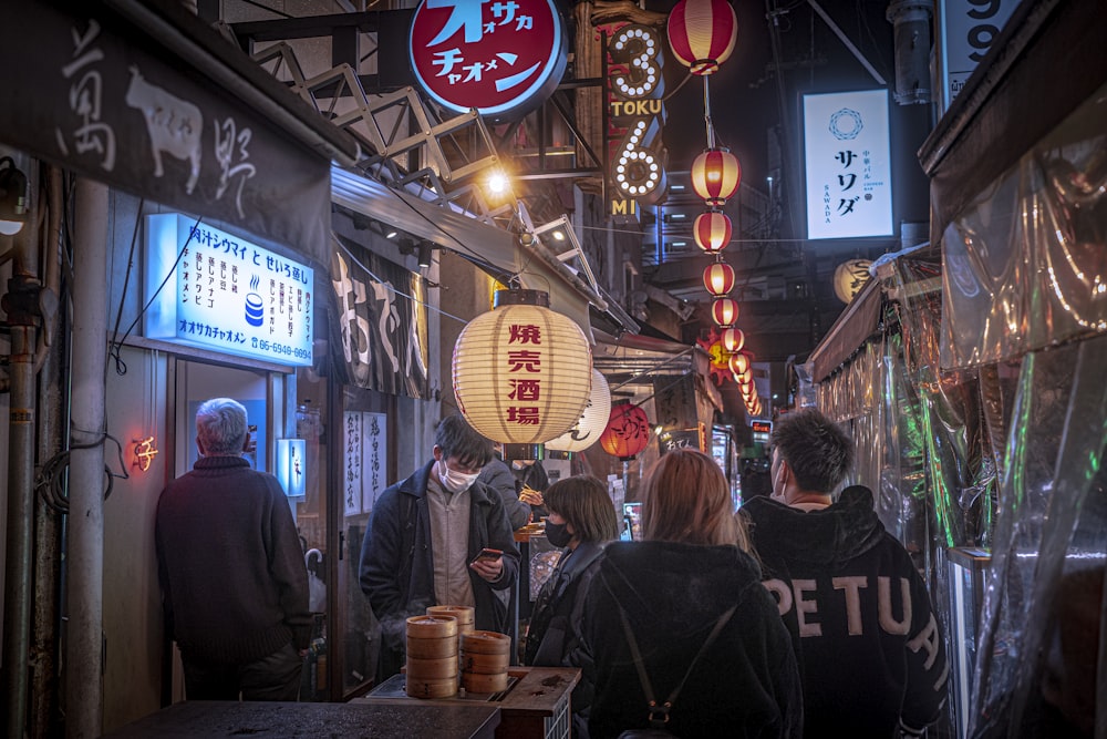 a group of people walking down a street at night