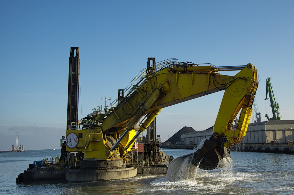 a large yellow machine is in the water