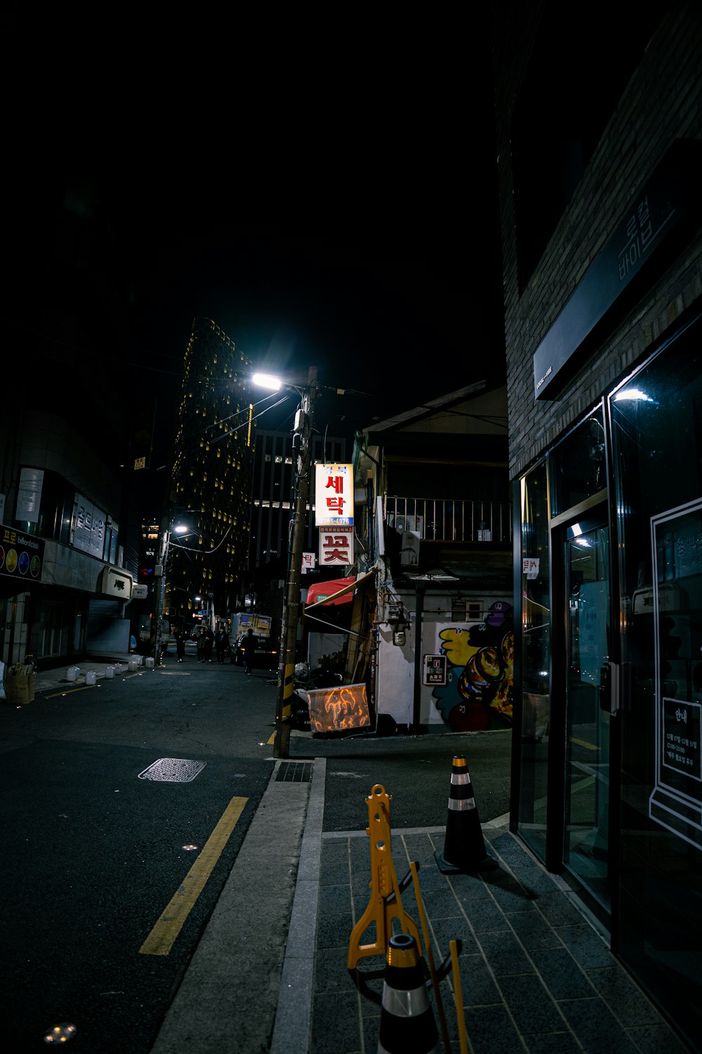 Una calle de la ciudad por la noche con un letrero de construcción