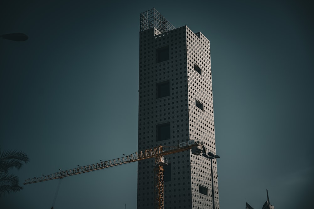 a tall building with a crane in front of it