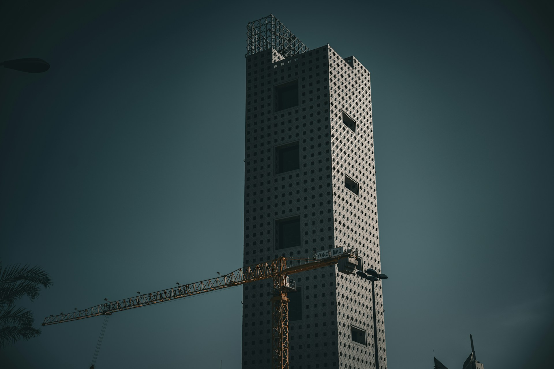 a tall building with a crane in front of it