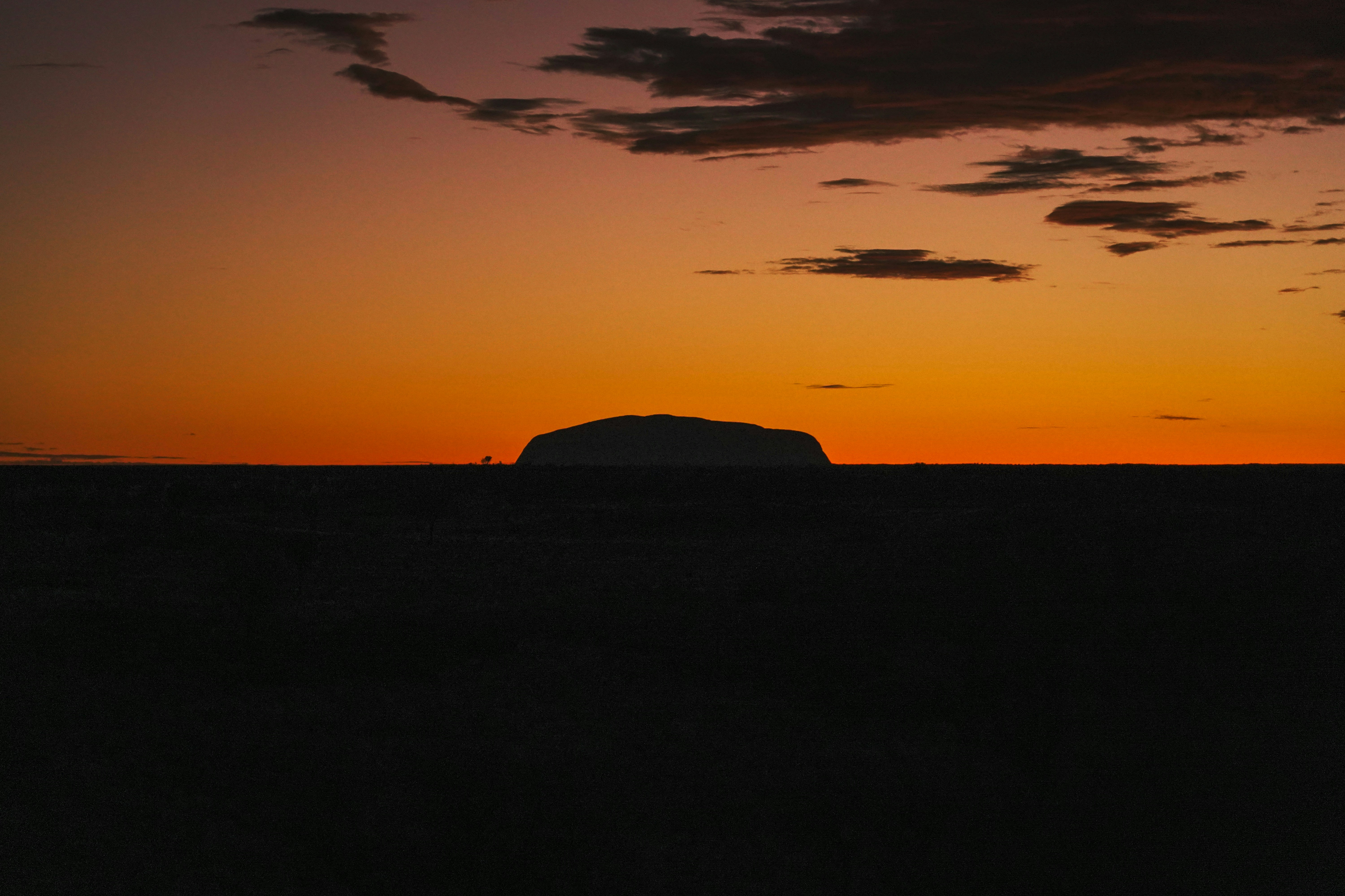 a large rock sitting in the middle of a field, Ayers Rock Sunrise