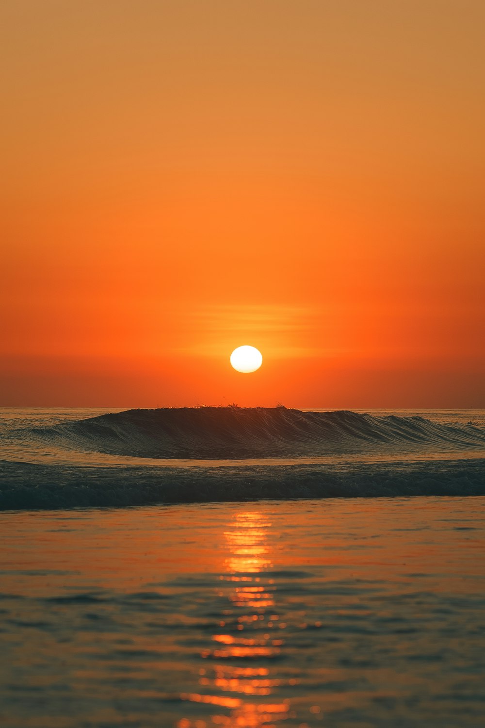 Die Sonne geht über dem Ozean mit Wellen unter