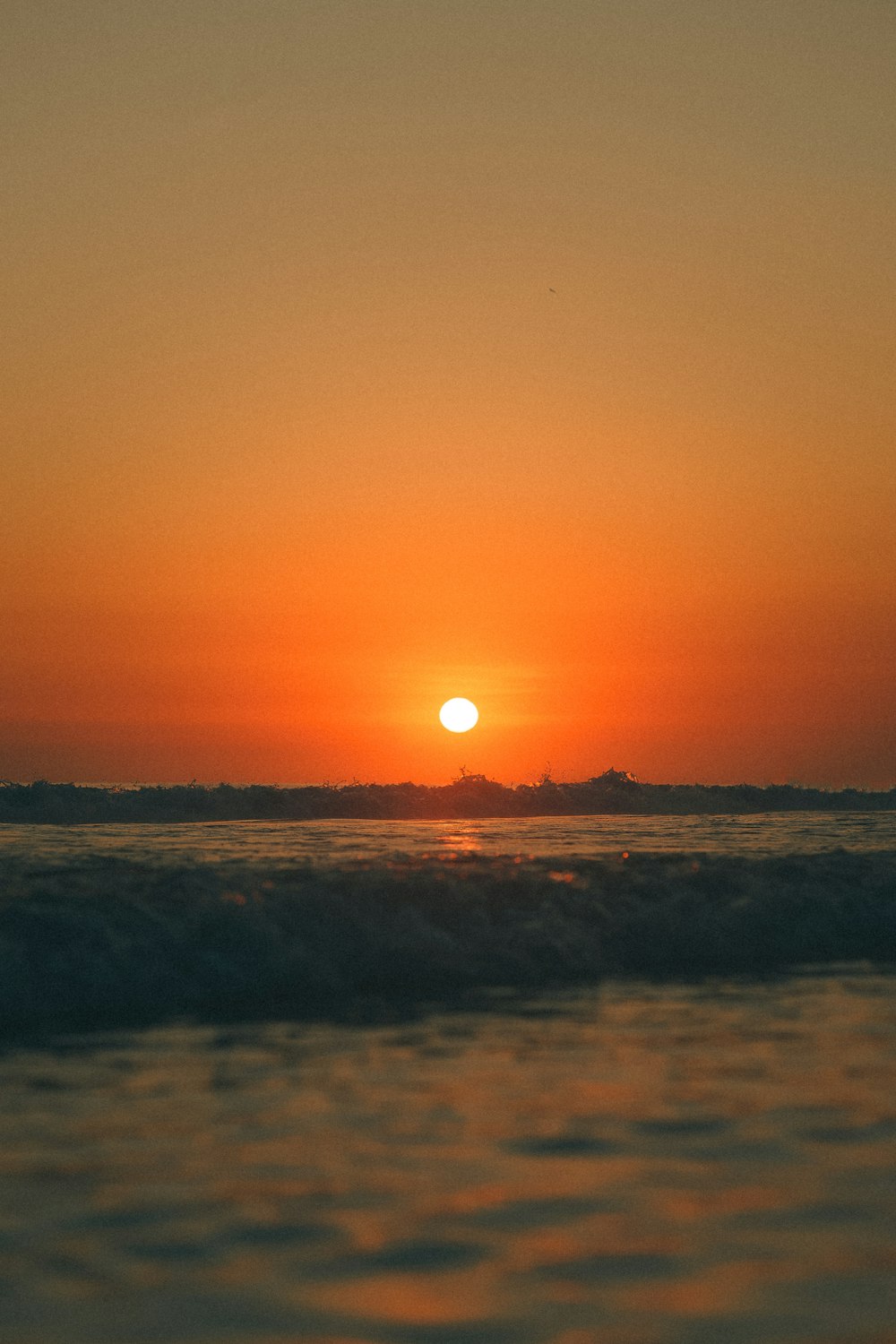 Le soleil se couche sur l’océan avec des vagues