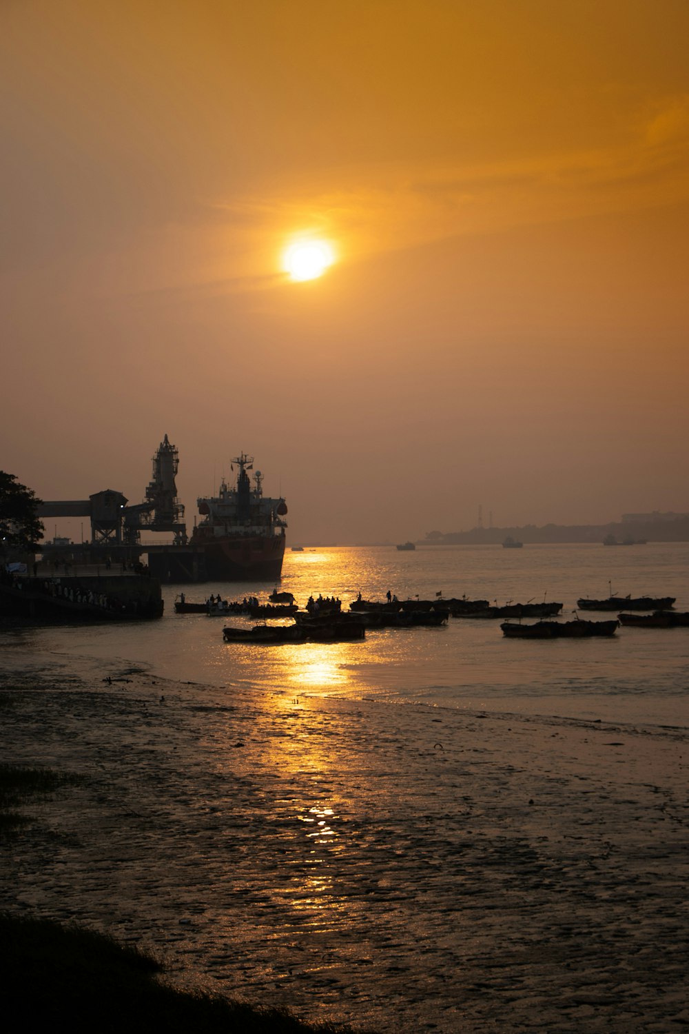 a sunset over a body of water with boats in the water