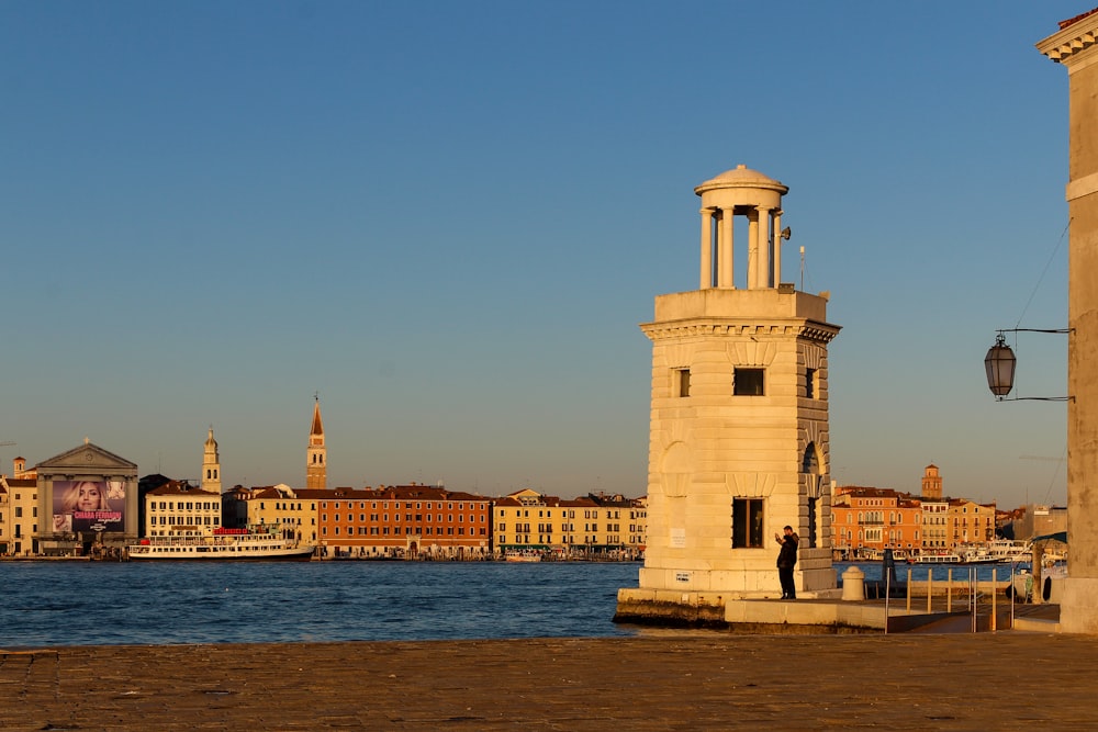 a clock tower sitting next to a body of water