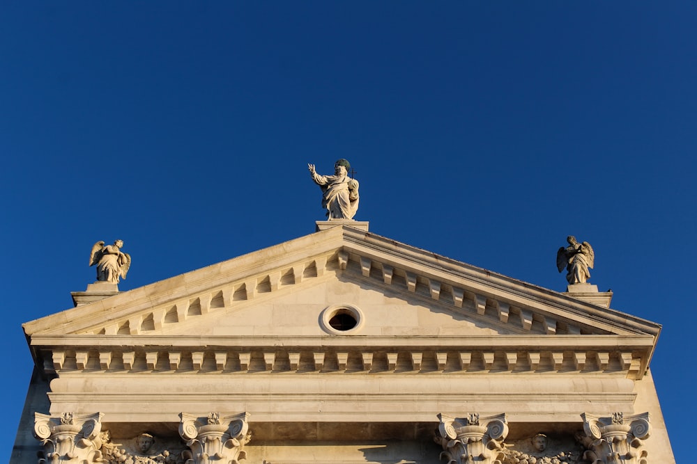 a tall building with statues on top of it