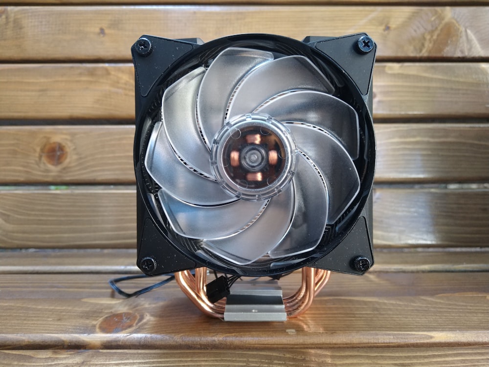 a computer fan sitting on top of a wooden table