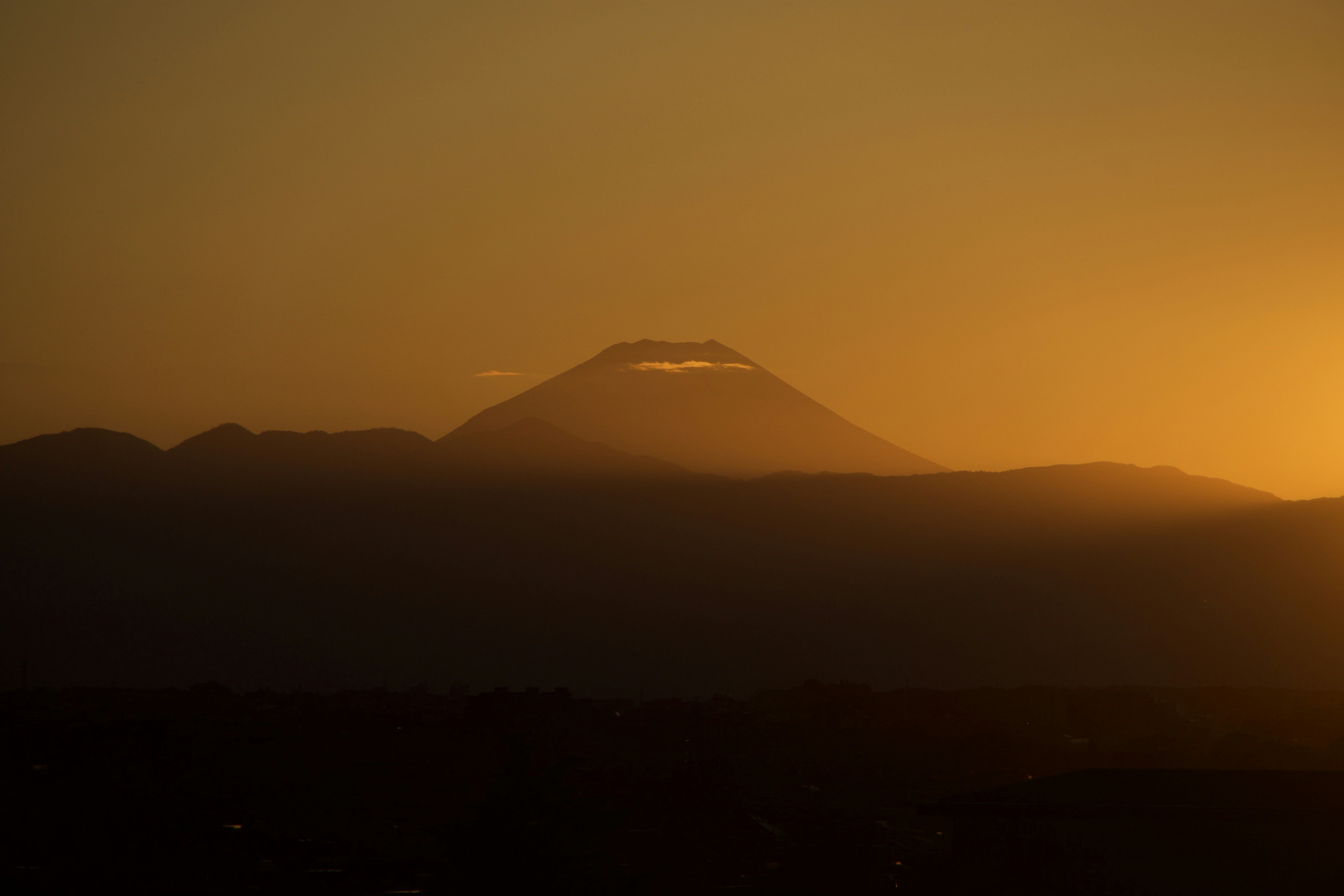 The sun is setting over a mountain range