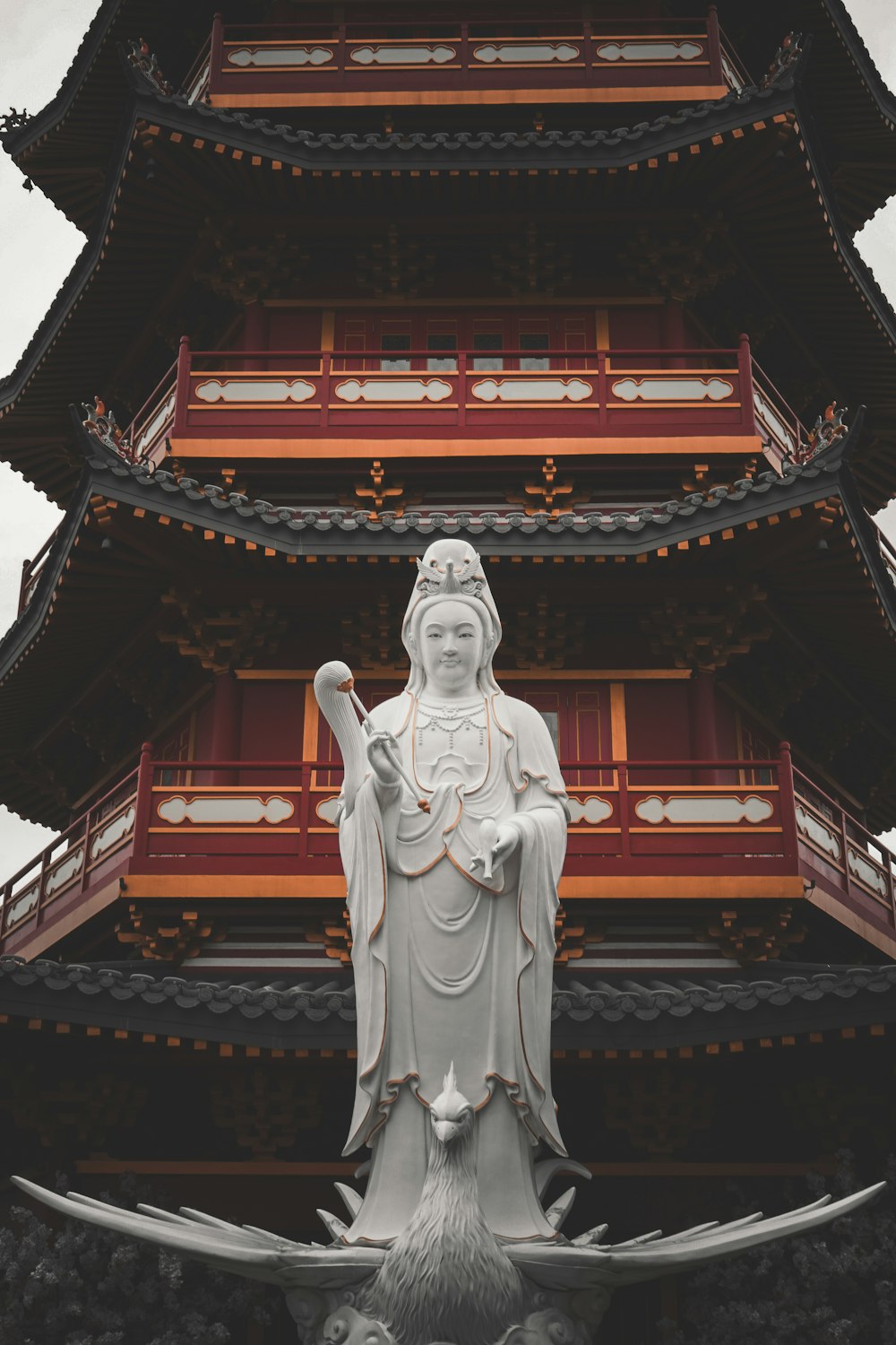 a statue of a woman in front of a pagoda