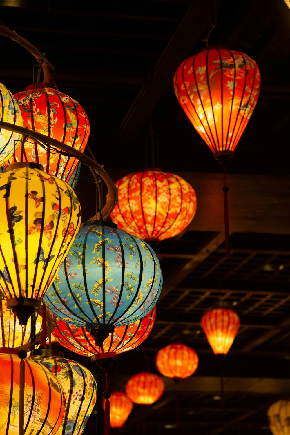 a bunch of colorful lanterns hanging from a ceiling