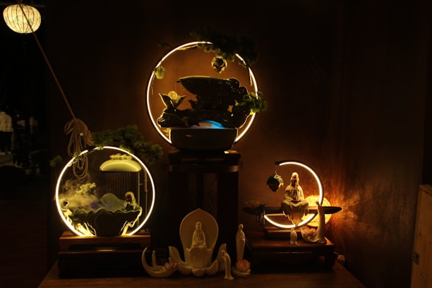 A serene display of earthy-toned spiritual murtis arranged on a rustic wooden shelf with warm ambient light.