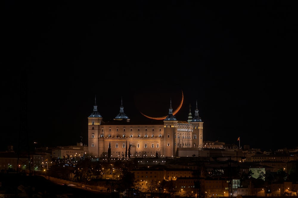Una vista nocturna de un gran edificio con una media luna en el cielo