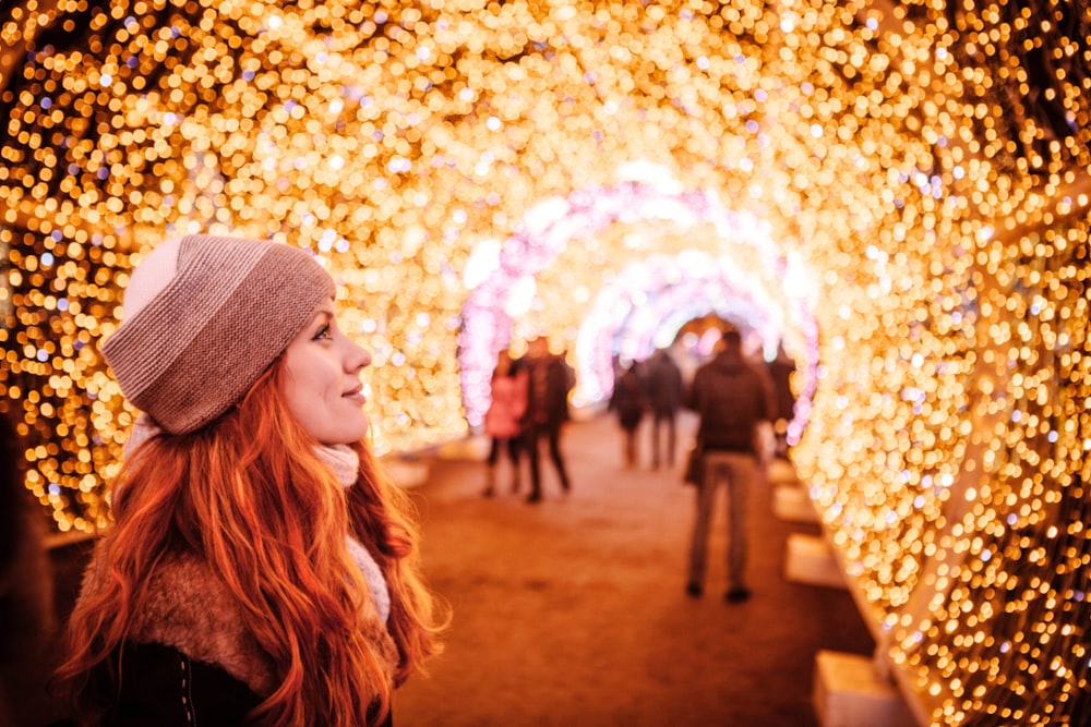 a woman standing in front of a tunnel of lights