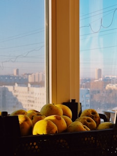 Bright and clean image of fresh fruits piled in baskets with sunlight streaming in from a nearby window.