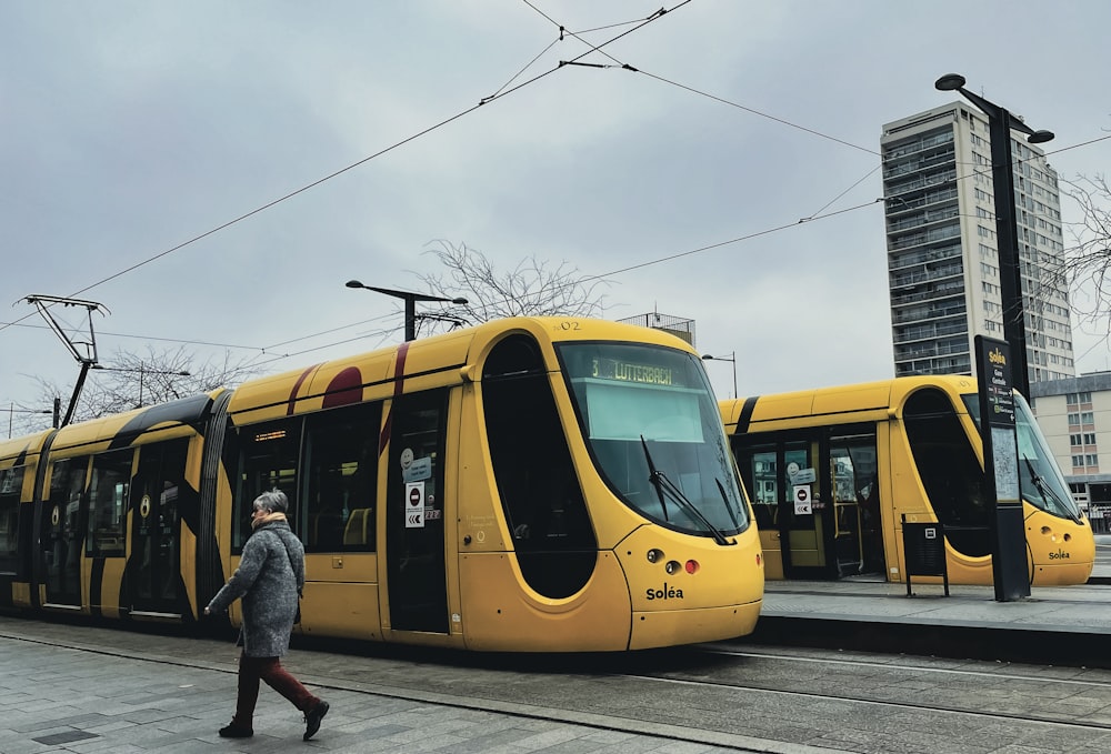 a person walking next to a yellow train