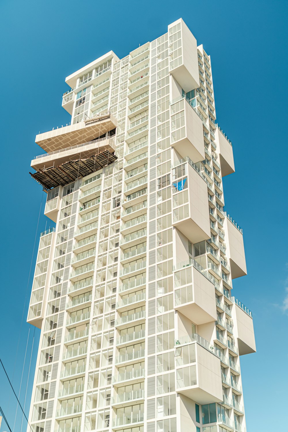 Un alto edificio bianco con balconi e finestre