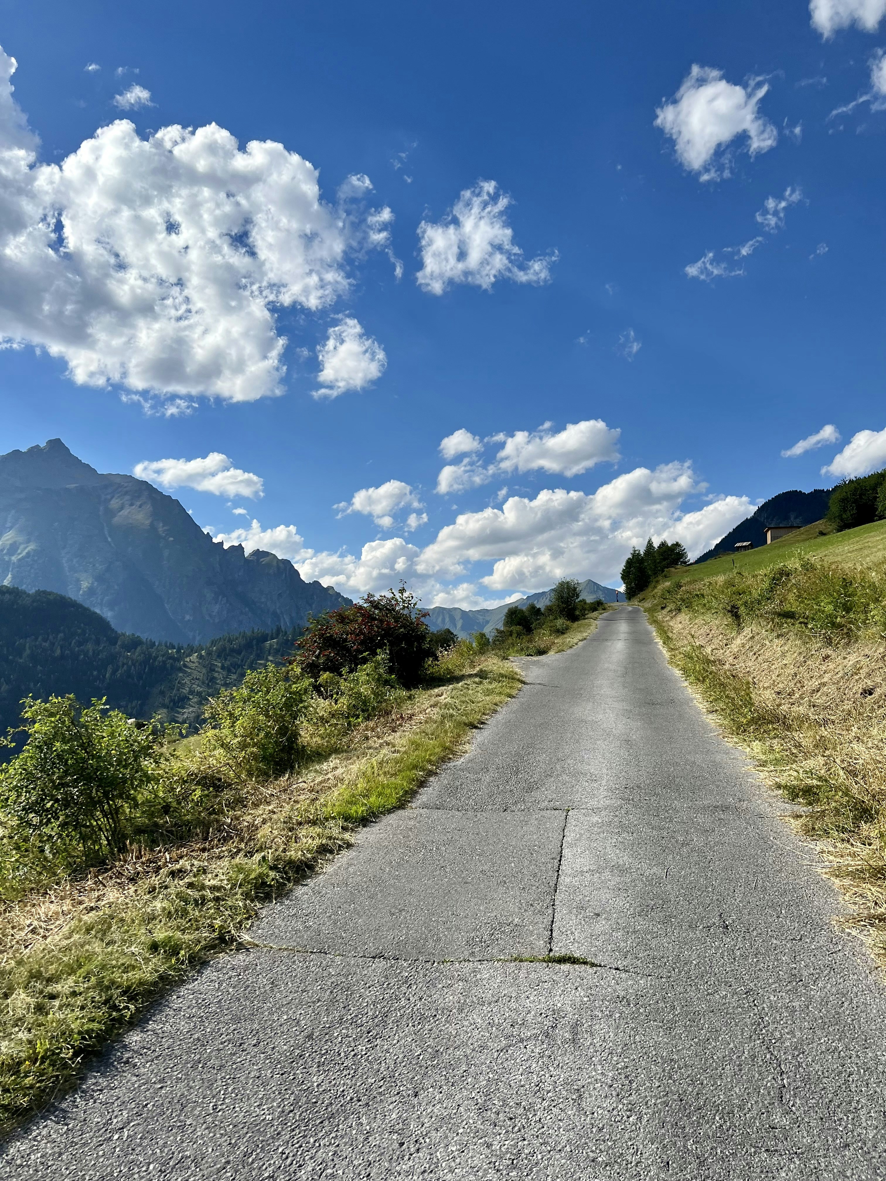 an empty road with mountains in the background