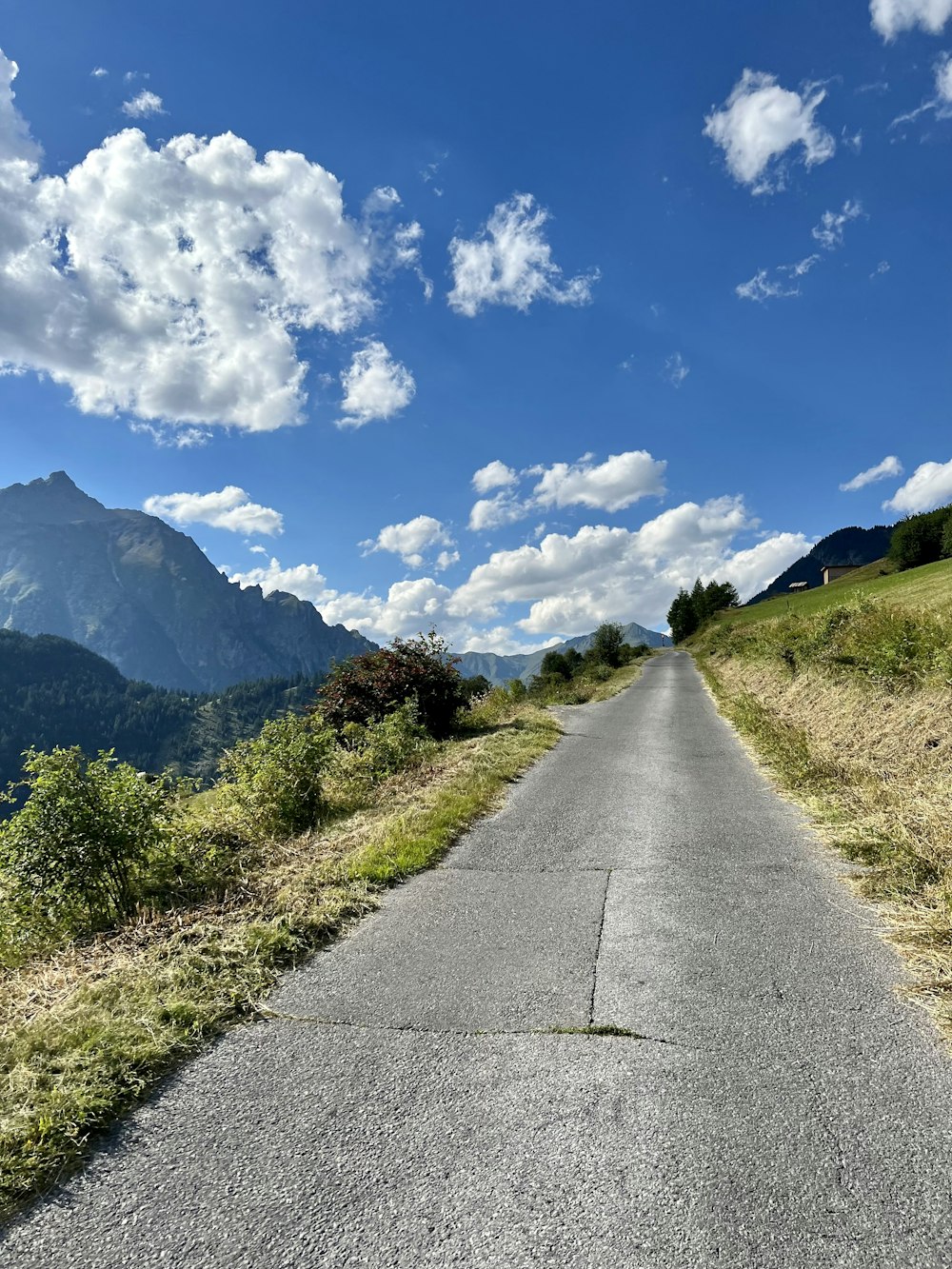 an empty road with mountains in the background