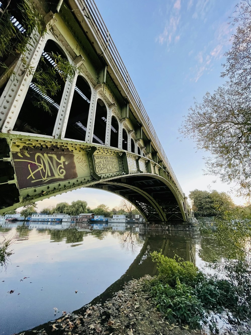 a bridge over a river with graffiti on it