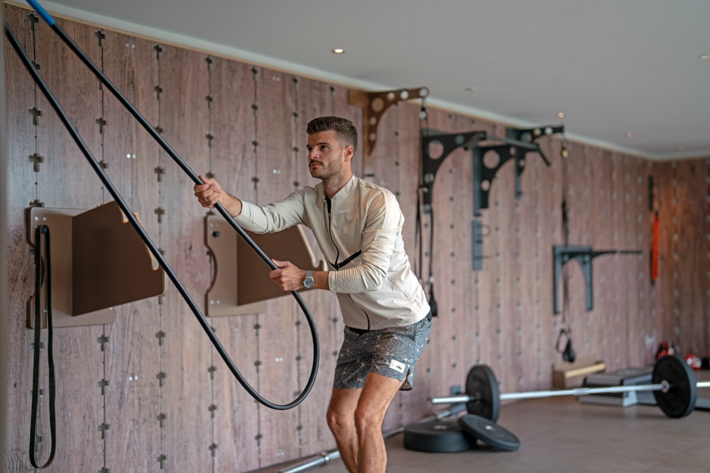 a man holding a gym rope in a gym