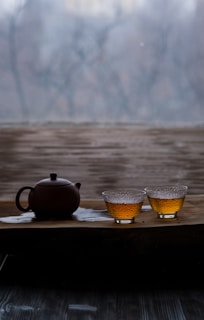 a tea pot and two cups on a tray