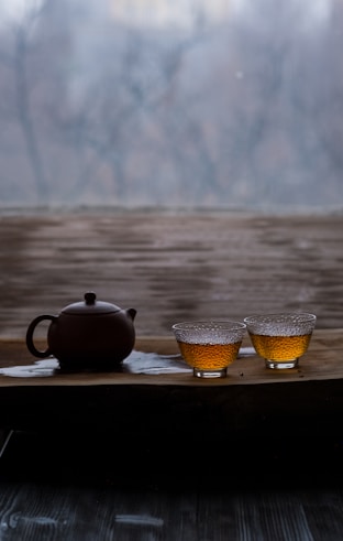 a tea pot and two cups on a tray