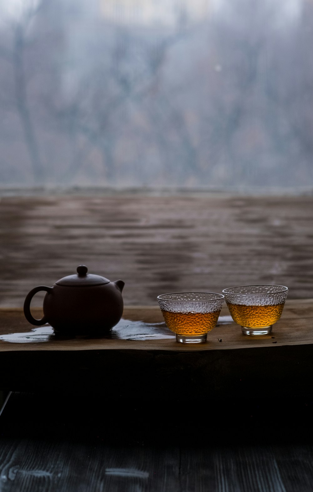 a tea pot and two cups on a tray
