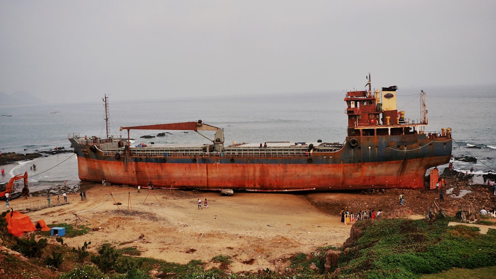 a rusted ship sitting on top of a sandy beach