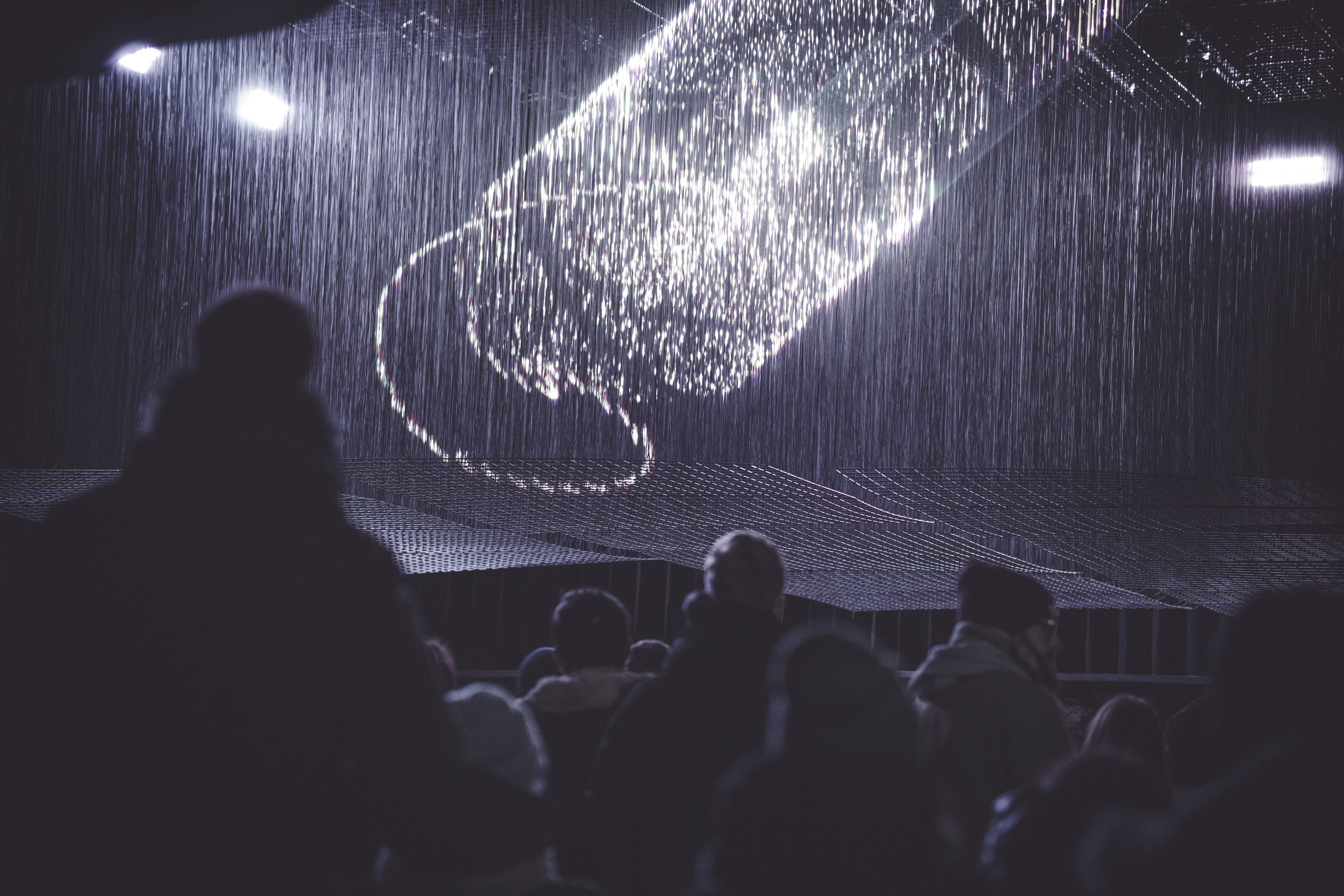 a person standing in front of a stage with a projection on it