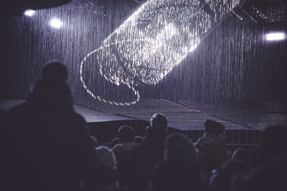 a person standing in front of a stage with a projection on it