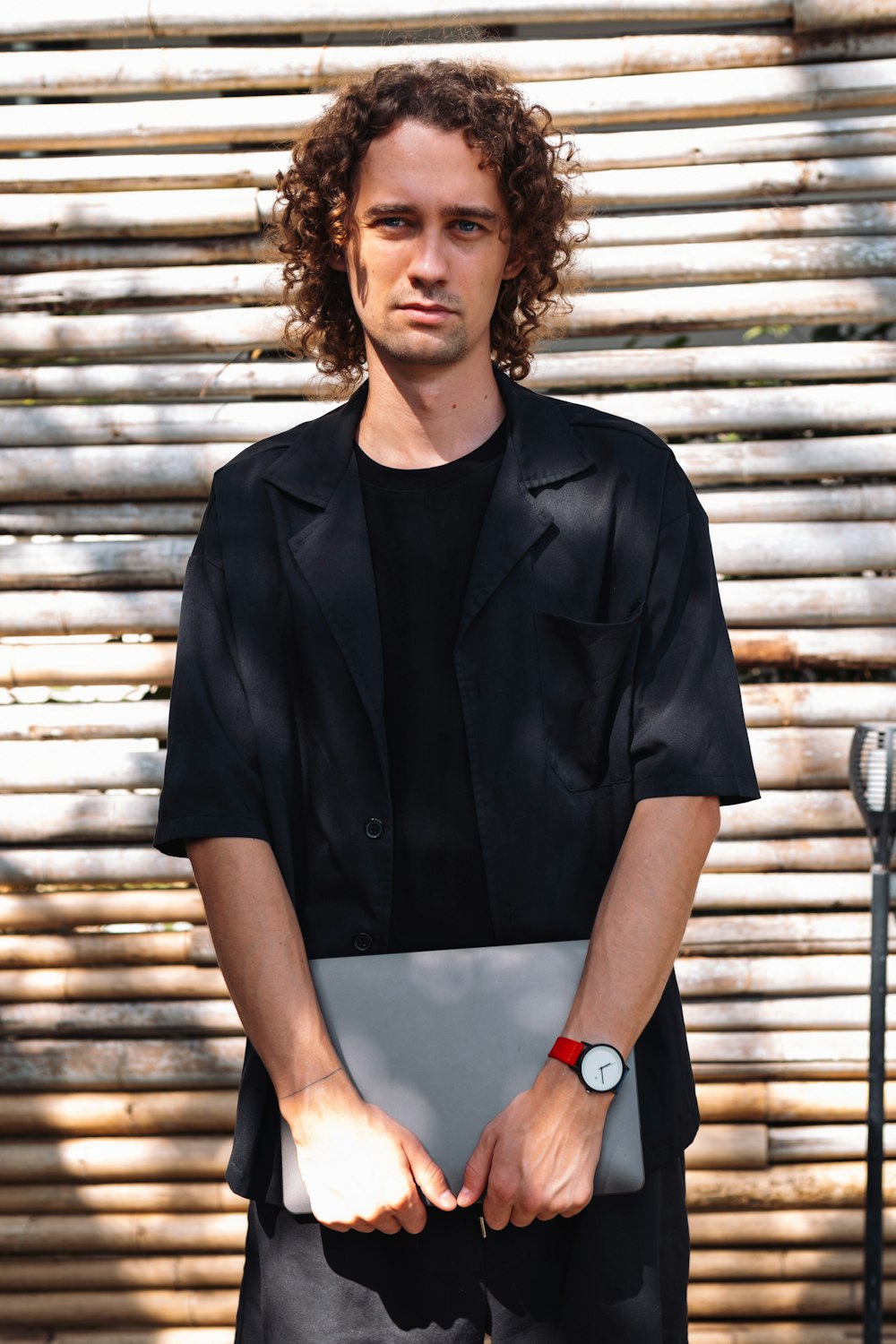 a man with curly hair holding a laptop