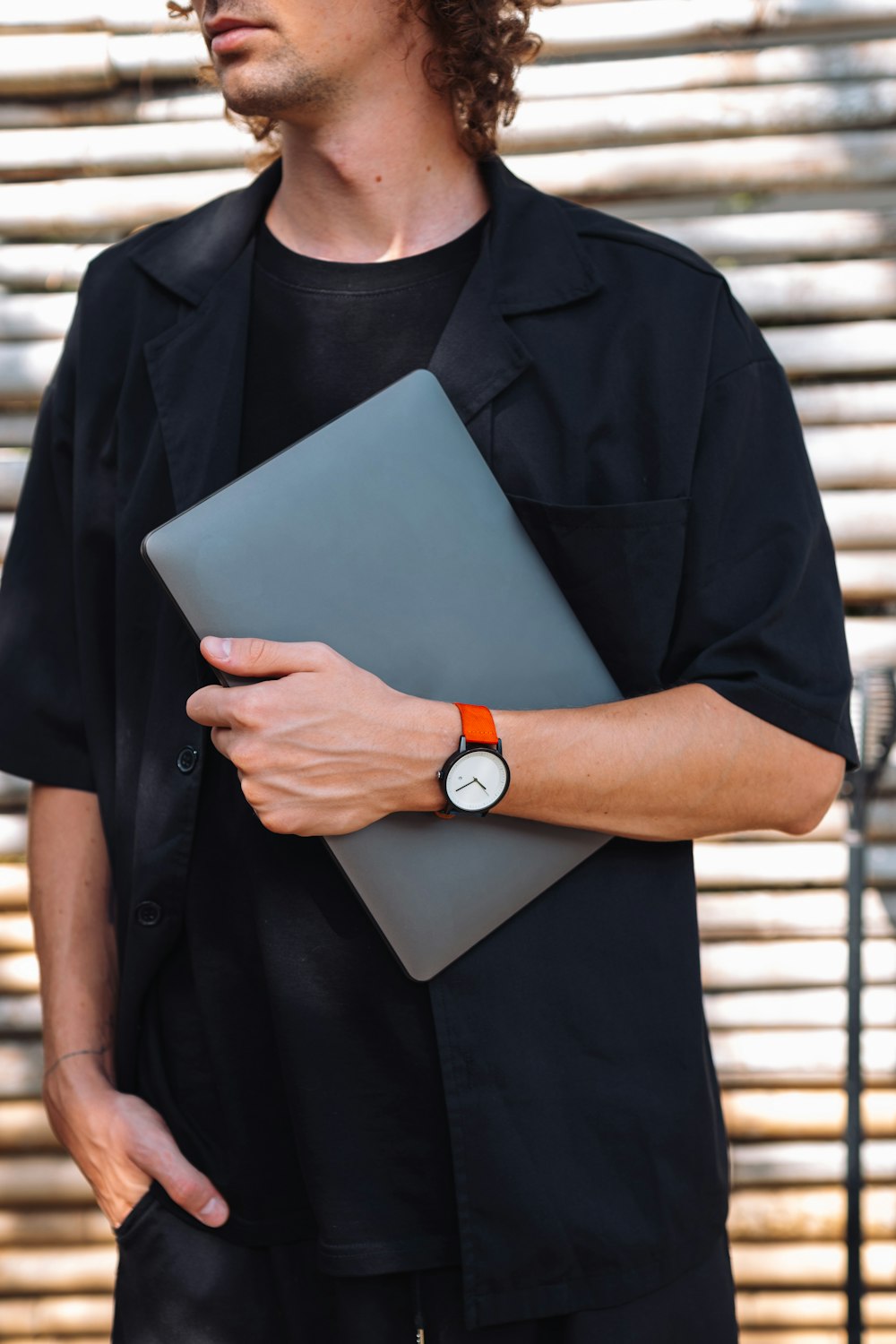 a man in a black shirt holding a laptop