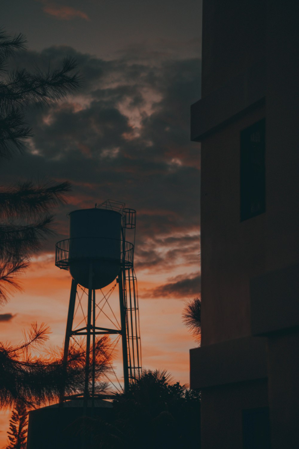 a water tower is silhouetted against a sunset