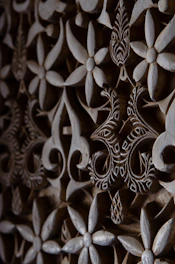 Close-up of a laser-cut wooden item with delicate floral designs.