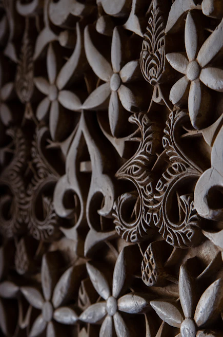 Laser engraving process on a wooden plaque showing intricate patterns