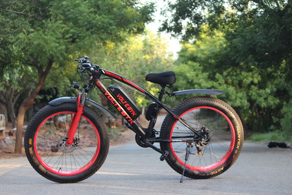 a red and black bike parked on the side of a road