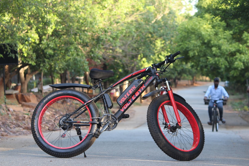 a red and black bike parked on the side of a road