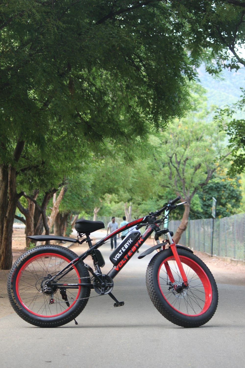 a red and black bike parked on the side of a road