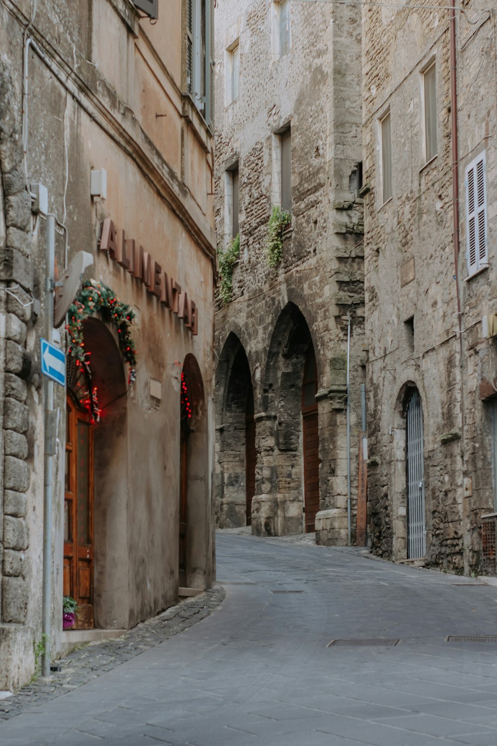 a narrow street with stone buildings and arched doorways