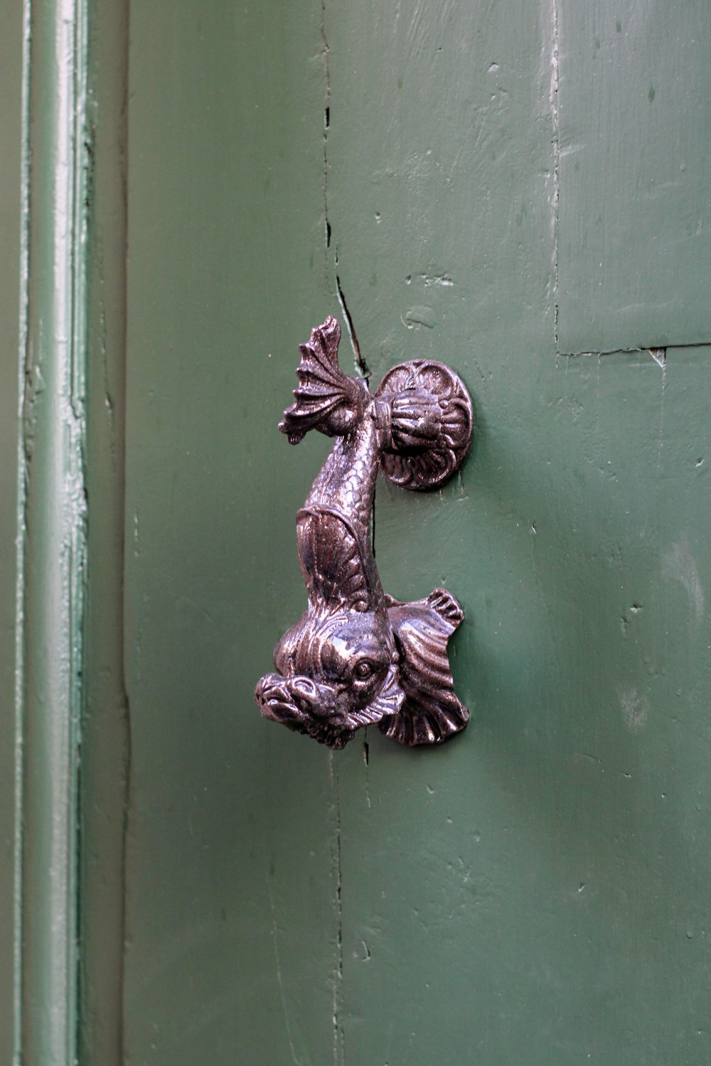 a metal door handle on a green door