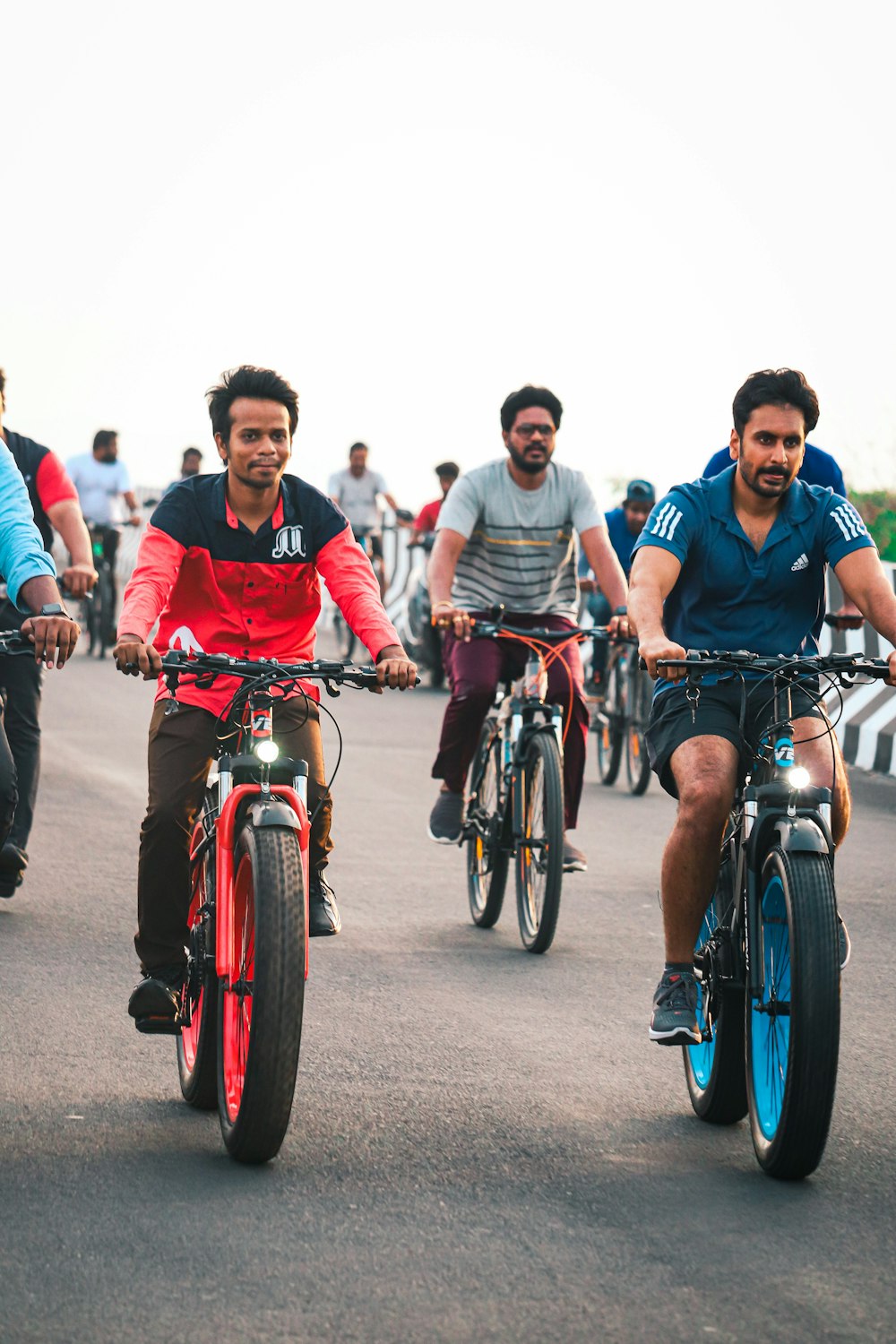a group of men riding bikes down a street