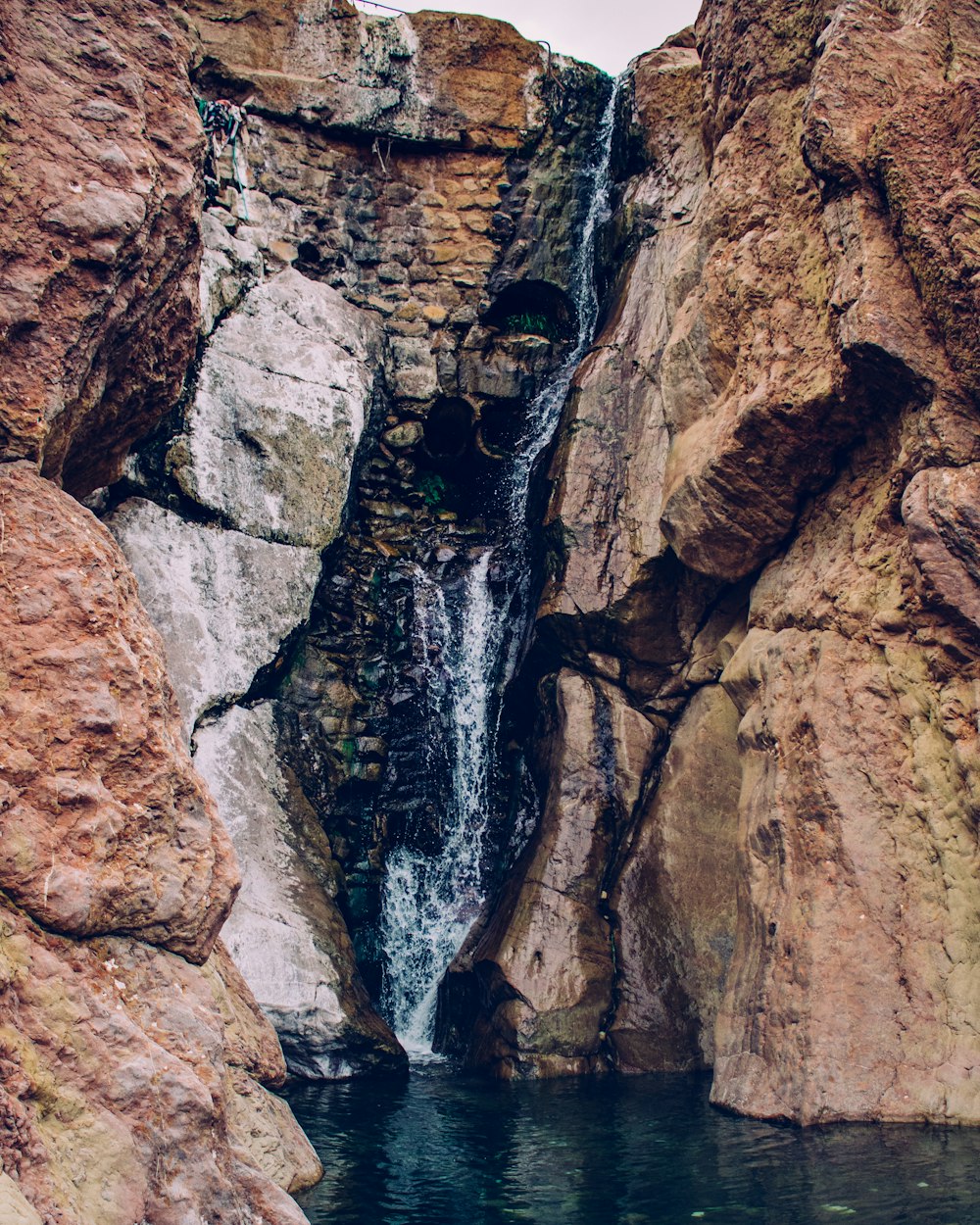 a man standing in front of a waterfall