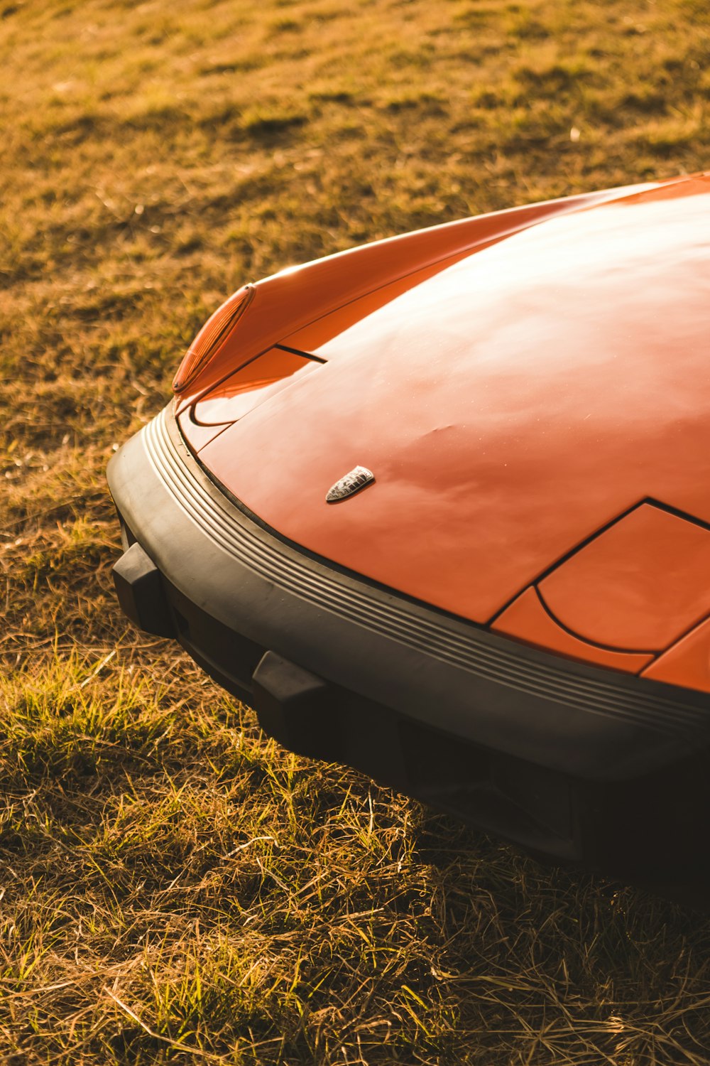 a close up of the hood of an orange sports car