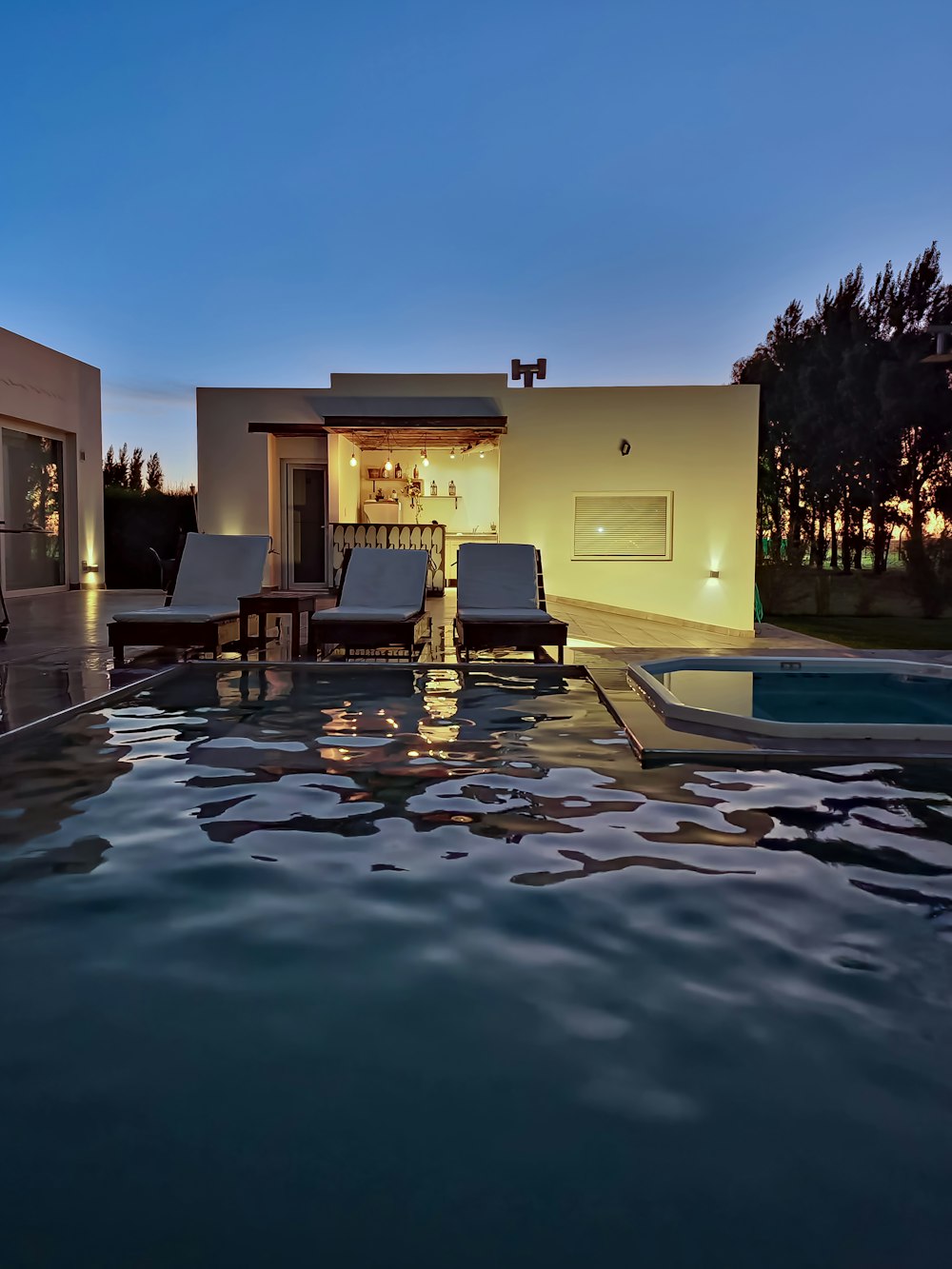 a house with a swimming pool at night
