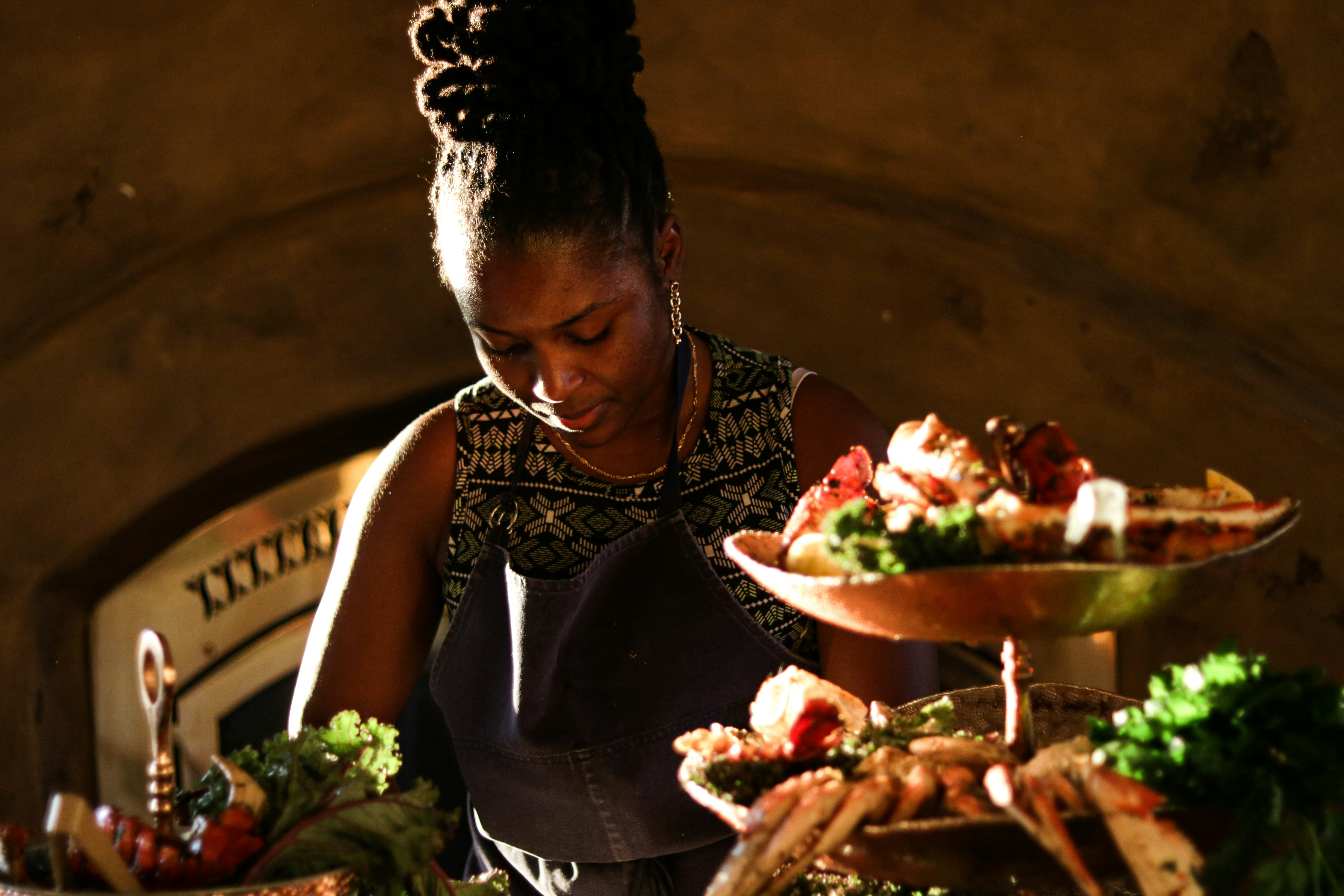a woman standing in front of plates of food, Let her cook