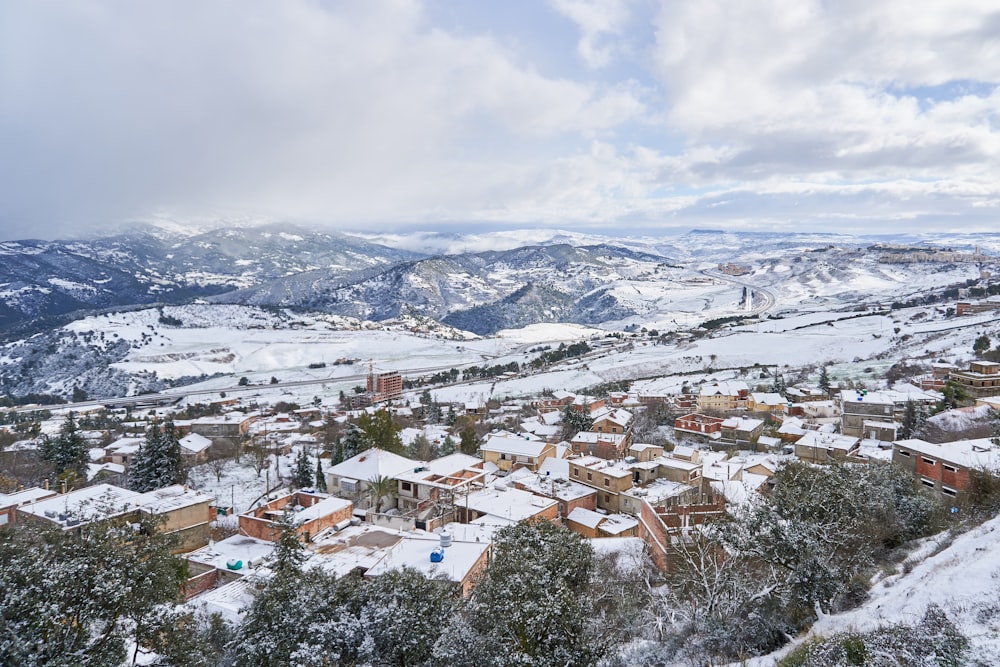 Un pueblo cubierto de nieve con montañas al fondo