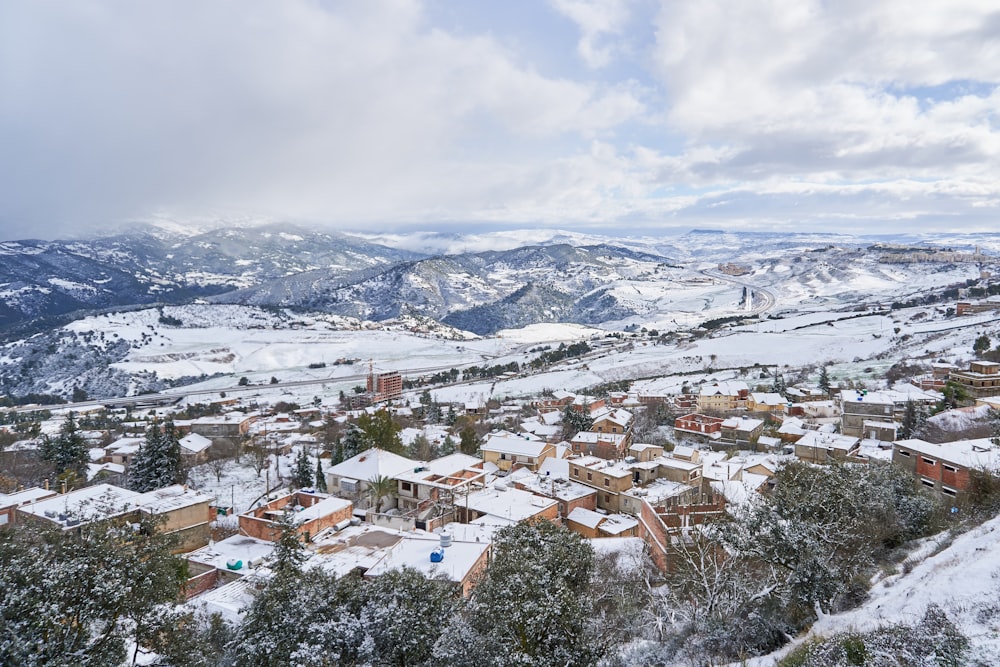 a snow covered town with mountains in the background
